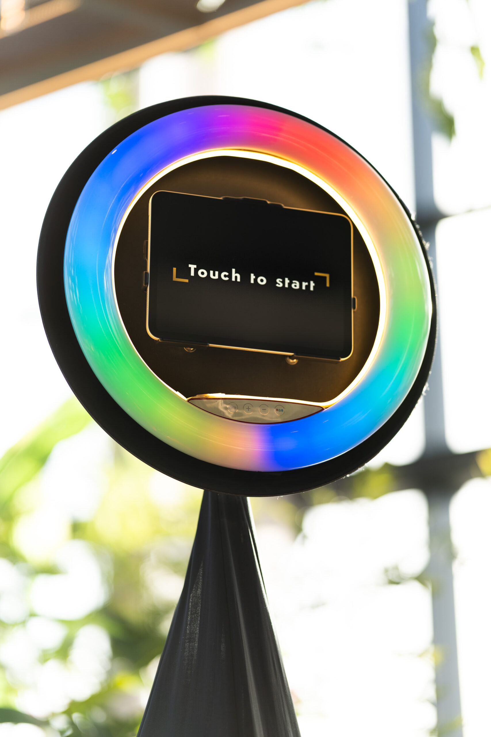 Twee gasten poseren lachend voor de Light Ring photobooth. Het slanke statief en de lichtring zijn duidelijk zichtbaar.